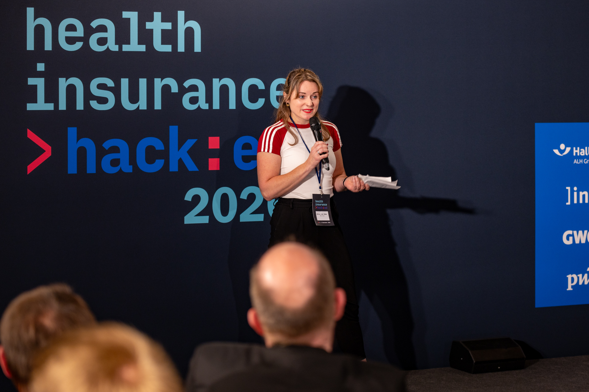 Vertreterin einer Partnerkasse pitcht ihre Challenge auf der Bühne beim health insurance hack:ed 2026
