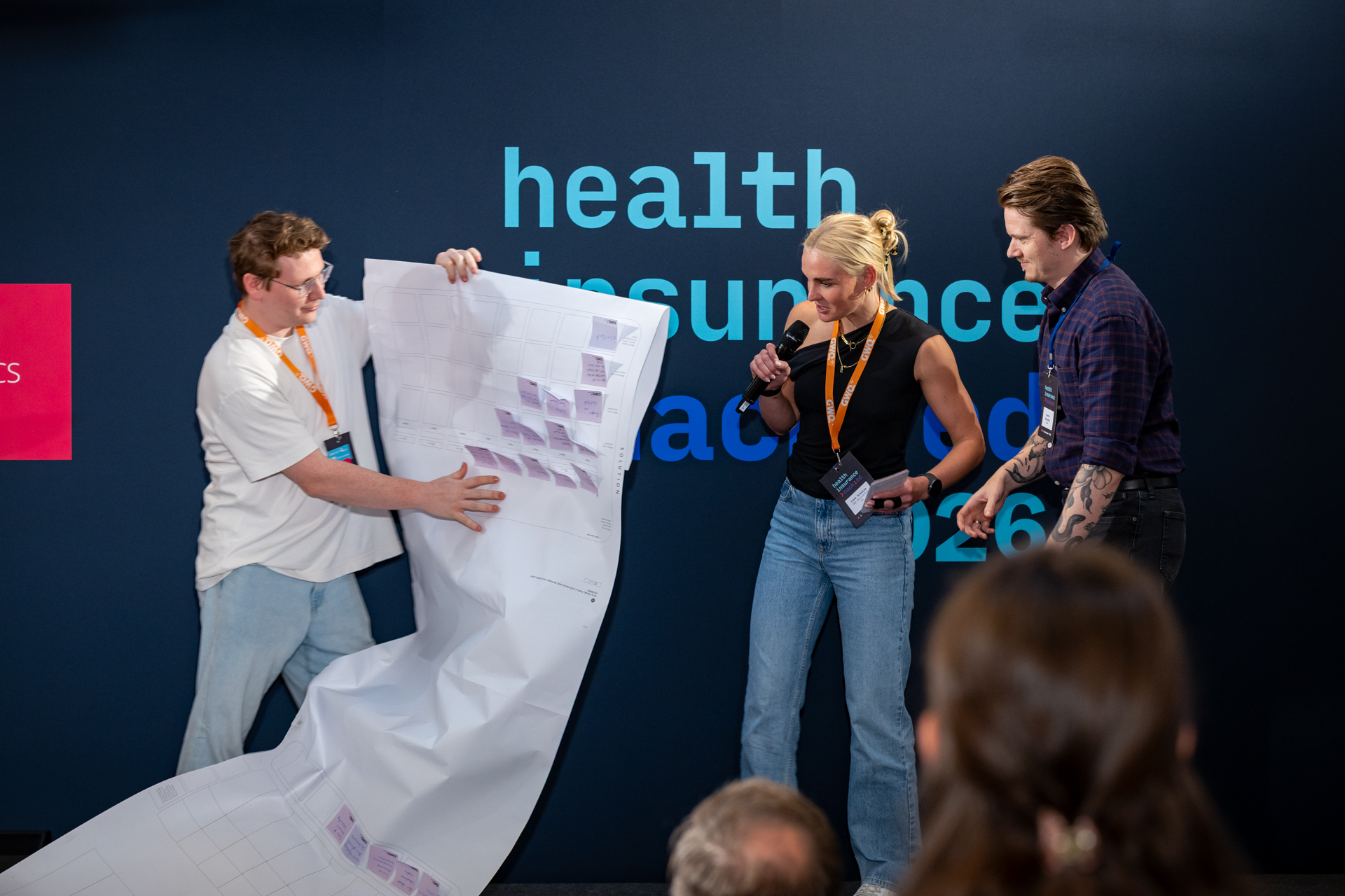 Team präsentiert seine Workshop-Ergebnisse auf einem großen Plakat im Plenum
